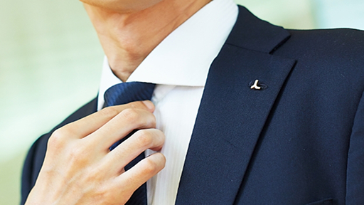 従業員一人一人が1日たりとも忘れないよう、社章には人の形を模した「人バッジ」を採用。